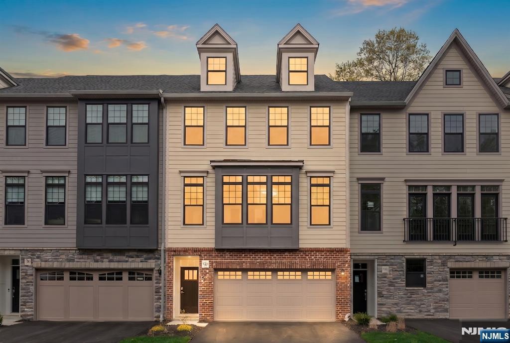 Welcome to this upgraded Dansfield model located in the most desirable section of the highly sought after Grove at Upper Saddle River. The open concept floor plan provides excellent natural lighting and is designed for both everyday living and entertaining, featuring a large eat-in chef's kitchen with a slider to the sun-soaked oversized deck, a great room with a gas fireplace, dining room and powder room. The kitchen offers a large center island, upgraded cabinetry, and full roll-out shelving for added convenience. Upstairs, the primary suite features an Elfa finished walk-in closet and a spa-like bath with oversized shower. Two additional bedrooms feature recessed lighting, and the hall bath includes a double sink vanity. A laundry room with front loading washer and dryer, and fully cabinetry, with sink, completes the upper level. The finished lower level provides flexible living space with an oversized recreation room, half bath and an attached 2-car garage. Upgrades throughout this home include a custom built-in wall unit in the great room, a fully tiled fireplace, hardwood flooring throughout, custom carpet runners on stairs and entrance, and custom window shades. Access to The Grove's luxury resort-style amenities including clubhouse, fitness center, pool, social room, business center & conference room included.