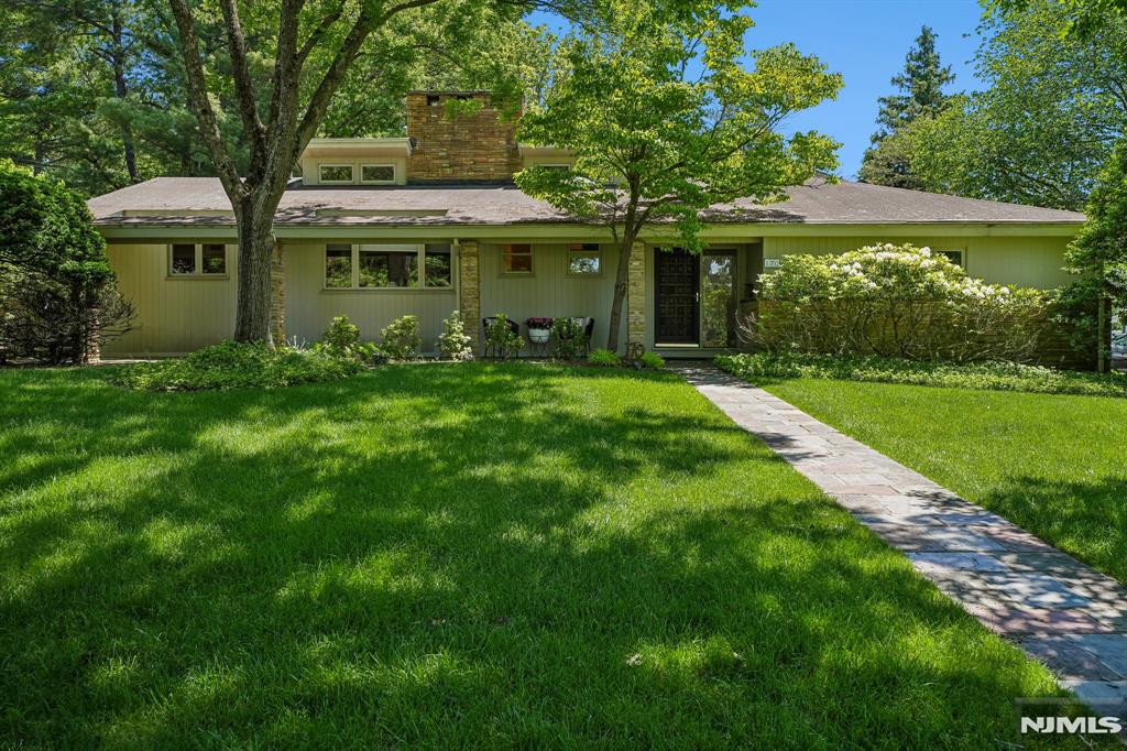 This exquisite, 3-bedroom, 3.2-bath mid-century Expanded Ranch is situated in the iconic Newstead section of S. Orange, located just minutes from the Villageâ€™s vibrant center. One of the original Newstead houses, it embodies timeless elegance with its modern clean lines and tasteful upgrades. The main living area features an open floor plan that seamlessly integrates a living room, dining room, and family room. Vaulted ceilings and a wall of windows create a versatile space that can serve equally as a dramatic venue for entertaining or for simply relaxing after a long day. The centerpiece of the house is its spectacular two-story stone fireplaceâ€”a true mid-century hallmark. The light-filled, eat-in kitchen leads to a conveniently located powder room. Off the main living area, the primary suite boasts a spacious closet wall and a tastefully updated, en-suite bathroom. A second bedroom and a beautiful full hall bathroom complete the first floor. Upstairs, a spacious third bedroom with its own full bathroom awaits. The partially finished basement features an oversized rec room equipped with a wet bar and powder room. Interior access to the two-car garage further enhances the convenience of this exceptional property. The tranquil backyard encompasses a spacious deck, accessible from both the dining room and the primary suite, ideal for al fresco living. Situated on a corner lot, surrounded by manicured shrubs and trees, this property provides a serene oasis from your busy wor