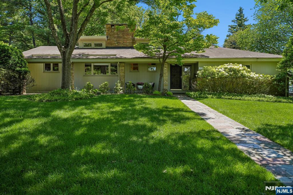 This exquisite, 3-bedroom, 3.2-bath mid-century Expanded Ranch is situated in the iconic Newstead section of S. Orange, located just minutes from the Villageâ€™s vibrant center. One of the original Newstead houses, it embodies timeless elegance with its modern clean lines and tasteful upgrades. The main living area features an open floor plan that seamlessly integrates a living room, dining room, and family room. Vaulted ceilings and a wall of windows create a versatile space that can serve equally as a dramatic venue for entertaining or for simply relaxing after a long day. The centerpiece of the house is its spectacular two-story stone fireplaceâ€”a true mid-century hallmark. The light-filled, eat-in kitchen leads to a conveniently located powder room. Off the main living area, the primary suite boasts a spacious closet wall and a tastefully updated, en-suite bathroom. A second bedroom and a beautiful full hall bathroom complete the first floor. Upstairs, a spacious third bedroom with its own full bathroom awaits. The partially finished basement features an oversized rec room equipped with a wet bar and powder room. Interior access to the two-car garage further enhances the convenience of this exceptional property. The tranquil backyard encompasses a spacious deck, accessible from both the dining room and the primary suite, ideal for al fresco living. Situated on a corner lot, surrounded by manicured shrubs and trees, this property provides a serene oasis from your busy wor