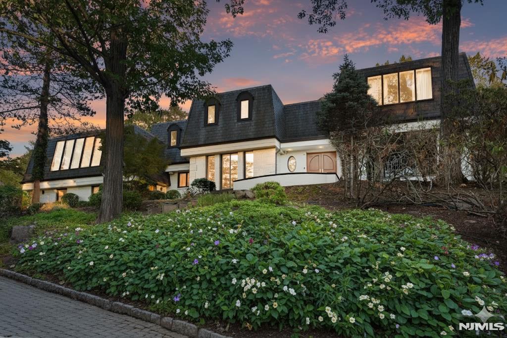 Escape to this private estate surrounded by nature and refined luxury. Set high on nearly an acre of exquisitely landscaped grounds bordering the Tenafly Nature Center, this residence offers unmatched privacy and scenic beauty. A true sanctuary, it features cascading waterfalls, a koi pond, lush gardens, and multiple stone terraces for relaxation and entertaining. At its heart, a new pool house with wet bar and bath overlooks the sparkling pool, outdoor fireplace, and expansive sitting areasâ€”creating a resort-caliber experience rarely found in Tenafly. Inside, timeless craftsmanship defines light-filled spaces including a gracious living room with fireplace, formal dining room, inviting family room, and gourmet kosher kitchen with custom cabinetry and professional appliances. The serene primary suite with spa bath is joined by five bedrooms, three full baths, a home theater, gym, and wine cellar. With slate roof, four-car garage, generator, and premier location, this estate epitomizes elegant modern living.