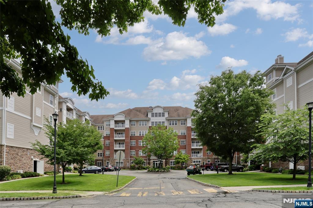 More than a home...it's a lifestyle. 1768 SF Colfax unit with a private hall entrance in the Del Webb 55+ active adult community of Wanaque Reserve set on more than 440 acres of beautifully landscaped and wooded grounds. Go out the side door of the building and you have the 20,000 SF clubhouse with indoor and outdoor pools, exercise room, cafe, sauna, billiards, and more than 45 clubs & activities. Some of the clubs are the travel club, casino trips, canasta, mahjong, poker, bocce, shuffleboard, ballet, art classes and many more. Tennis and pickleball courts are across the street. This home features beautiful wood floors, living room with sliding doors to the balcony, dining room, den/home office with French doors adding a touch of elegance, eat-in-kitchen with stainless steel appliances, granite countertop, tile backsplash, plenty of cabinets and pantry, laundry room off the kitchen, primary bedroom ensuite with tray ceiling, walk-in-closet with custom California closet, additional closet, full bath, walk-in-shower, double vanity and private toilet room, 2nd bedroom and full bath. Wanaque Reserve offers a luxurious lifestyle for its residents with a focus on modern amenities, security and a sense of community. The recent renovation adds a fresh and updated living environment.