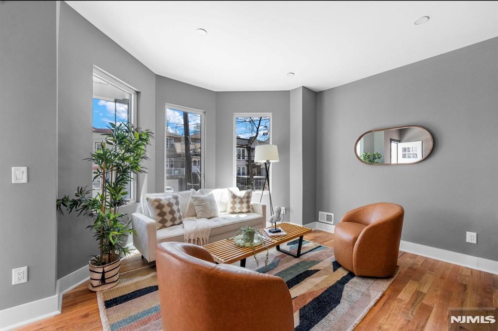 Experience elevated Jersey City living in this spectacular upper-level duplex condominium offering approximately 4 bedrooms, 3 full bathrooms, and breathtaking New York City skyline views. Designed for modern living, this sun-drenched residence features soaring ceilings, oversized windows, hardwood flooring, and a seamless open-concept layout. The chef-inspired kitchen showcases a large center island, premium finishes, and ample storage while flowing effortlessly into the expansive living and dining areas. Wake up to stunning NYC skyline views from the luxurious primary suite, complete with a beautifully appointed ensuite bathroom. The additional bedrooms provide generous space for family, guests, home offices, or flexible living arrangements. Natural light pours throughout both levels, creating an airy and inviting atmosphere rarely found in condominium living. Every detail has been carefully selected to blend contemporary elegance with functionality. Perfectly situated in Bergen-Lafayette, one of Jersey City's fastest-growing neighborhoods, you'll enjoy convenient access to Liberty State Park, Light Rail service, PATH transportation, Downtown Jersey City, local cafés, restaurants, and Manhattan