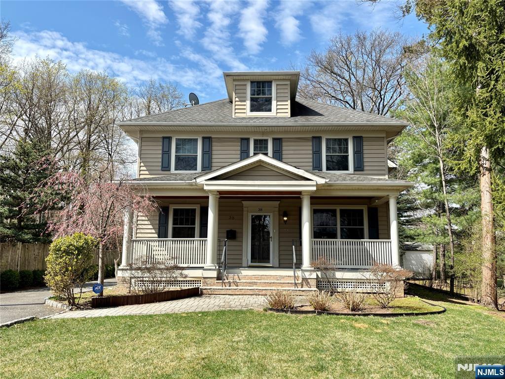 Built in 2005, this approx. 4,000 SF, 5-bedroom, 3.5-bath young Ridgewood colonial sits on a deep, park-like property with front and rear yards and a detached two-car garage. A welcoming front porch leads into the living and dining rooms, with a classic turned staircase featuring a mid-landing for a more comfortable ascent. The family room features cathedral ceilings, fireplace, and abundant natural light, with an adjoining private library. The kitchen is designed for everyday use, offering a generous island, ample cabinetry, and a bright dining area with direct access to the backyard. A powder room completes the first floor. The second floor includes a primary suite with a large bedroom, oversized walk-in closet, and a bath with tub and separate shower, along with two additional bedrooms and a full bath. The third floor offers two more bedrooms with built-in window seats and a shared bath. Hardwood floors throughout. A full unfinished basement with good ceiling height offers excellent potential for future use. Close to Saddle River County Park and NJ Transit bus #163 for NYC commuting. A solid, young home offering the benefits of newer construction rarely found in the area, with expansion potential in a convenient location.