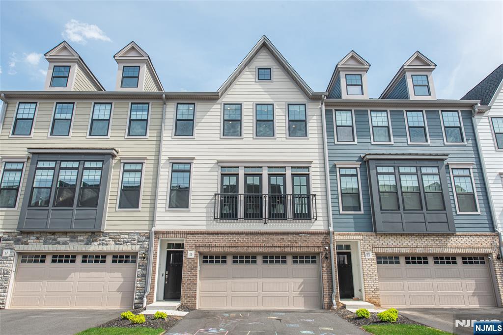 Welcome to The Grove at Upper Saddle River. This Briercliff model features extensive builder upgrades and backs to a private wooded setting. The open concept floor plan provides excellent natural lighting and is designed for both everyday living and entertaining, featuring a main-level office and a dining area with sliders to a deck. The kitchen offers a large center island, upgraded cabinetry, and full roll-out shelving for added convenience. Upstairs, the primary suite features a finished walk-in closet and a spa-like bath with a rain shower. Two additional bedrooms feature finished closets, and the hall bath includes a double sink vanity. A laundry room with added cabinetry completes the upper level. The finished lower level provides flexible living space with a recreation room that walks out to a paver patio, along with built-in shelving and space for a mini fridge. Upgrades throughout include custom hardwood flooring, iron rod railings, a stone fireplace, Sonos sound system, custom blinds, enhanced pantry shelving, and built-in garage storage. Excellent location - minutes from two train stations, bus stops, major highways, restaurants, shopping and entertainment. A perfect blend of style, function, and privacy move right in and enjoy.