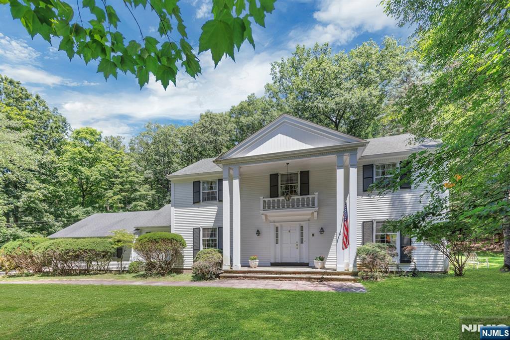 Set on over 1.8 private acres in the sought after South Gate section of Urban Farms in Franklin Lakes, this expansive 4 bedroom, 2.5 bath home offers a rare opportunity to move right in, renovate to your taste, or build new on a beautiful property surrounded by nature. Hardwood floors run throughout the home, beginning with a welcoming foyer and spacious living room. The main level features a formal dining room, an eat in kitchen, first floor laundry, powder room, and access to the attached 2 car garage with separate attic storage. The inviting family room showcases exposed wood beams and a fireplace, with sliding doors opening directly to the patio and heated inground pool. Just beyond, the heated sun porch provides additional year round living space with more sliders leading outdoors, creating seamless indoor/outdoor flow for entertaining and everyday enjoyment. Upstairs are four generously sized bedrooms, including a primary suite with a large built in vanity area and private bath. A partially finished basement adds flexible recreation, office, or storage space. The grounds are truly exceptional, offering privacy, mature landscaping, and endless room for play, exploration, and relaxation. Enjoy mountains in the rear and a stream enhancing the natural beauty in front with hiking trails and the Indian Trail Club just moments away. A unique opportunity to enjoy the home as-is, update over time, or create your dream estate in one of Bergen Countyâ€™s most desirable communities
