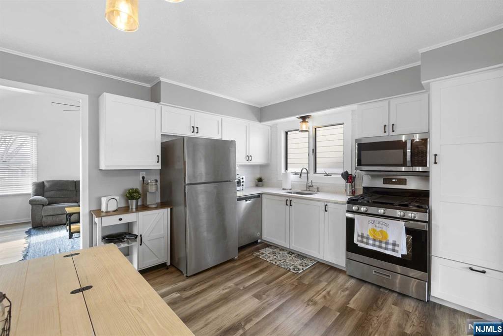 Discover the charm of this delightful Point Pleasant Beach home, featuring 3 bedrooms, 1 full bath, and 1 half bath. The ground floor welcomes you with a spacious family room, a convenient half bath, and ample storage space. The first floor offers three comfortable bedrooms, a full bath, a cozy living room, and a well-appointed kitchen, all complemented by a second family room overlooking the backyard. Enjoy the convenience of central heating and cooling throughout the home, ensuring comfort in all seasons. The property also includes a wood-burning fireplace on the ground level, adding warmth and character. A wide driveway provides parking for 2-4 cars, making it perfect for hosting gatherings. Situated near the beach, restaurants, shops, and public transportation, this home offers easy access to all that Point Pleasant Beach has to offer. This property is ideal for those seeking a well-located and comfortable home. Please note that the owner holds an active real estate license.