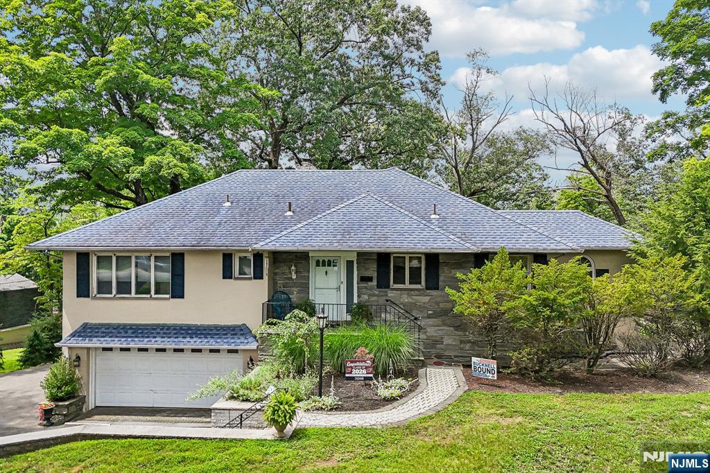 Welcome home to this well-maintained 3-bedroom, 2-bath Raised Ranch nestled on 1.37 protected wooded acres backing directly to the Point View Reservoir, offering breathtaking sunset views, unmatched privacy, and a rare waterfront setting just minutes from NYC transportation and top-rated schools with elementary and middle school busing. A welcoming entry foyer leads into the eat-in kitchen featuring custom cabinetry, ample counter space, stainless steel appliances, and a separate dining area. The kitchen flows seamlessly into the elegant dining room, which opens to the inviting living room highlighted by a wood-burning fireplace and sliding glass doors leading to a balcony overlooking the wooded landscape. The spacious primary bedroom offers two closets, while two additional bedrooms and a full bath complete the main level. The finished lower level provides exceptional flexibility with a family room, second fireplace, den, laundry room, full bath, and a sun-filled three-season room. A third fireplace adds warmth and character, while the partially finished attic offers additional storage. Relax outdoors in the gazebo, covered patio, open patio, or around the fire pit while enjoying fishing, entertaining, or the tranquil surroundings. Major updates include a newer roof, septic system, deck, garage door opener, and 10-car driveway. Whether you choose to enjoy the home as is, renovate, expand, or build your dream home, this is a truly rare waterfront opportunity.