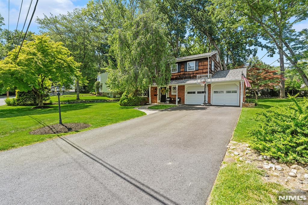For just the second time in 60 years, this grand colonial sitting on a half acre tree-filled estate located in a quiet family-friendly neighborhood has come to market! Be the third owner of this timeless oversized gem conveinent to top-rated schools, NYC commuter train, great restaurants & plenty of shopping. Step right into the welcoming entry foyer with its original slate tile that flows into the large formal dining, huge eat-in kitchen, powder room, spacious family room with tiled accent wall & built-ins & attached 2-car garage. The pantry mudroom open to a newly installed walking path leading to a massive deck overlooking the greenery, mature landscaping & newly graded yard with plenty of room to BBQ, entertain, garden & even add chickens. Back inside, the private living room boasts a valted ceiling with beams, contemporary custom built-ins & a modern electric fireplace with black shiplap surround & a natural wood mantle. Upstairs, four generously sized bedrooms await, one showcases a pitched ceiling and double closets as well as the updated hall bath. The primary suite features a walk-in, second closet & newly renovated ensuite bathroom. Downstairs, the basement hosts landry, storage & a brand new water heater. Both the roof & driveway were recently done. Walking distance to the school & a park with pickelball, dog run & pond stocked for fishing. This is a rare opportunity to experiene the best of tranquil suburban living without sacraficing any of the urban amenities!