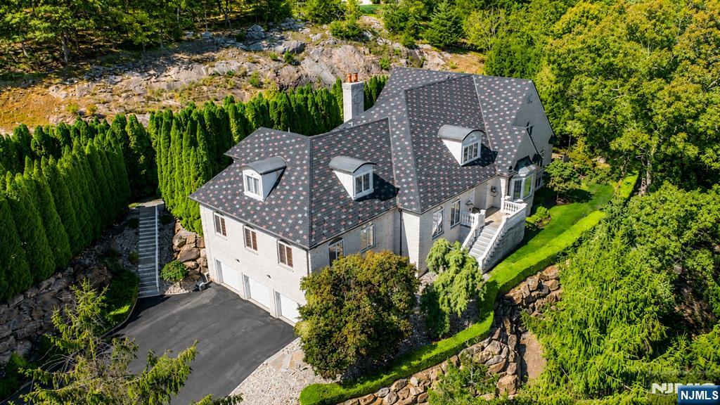Discover an extraordinary estate featuring a FIRST FLOOR PRIMARY SUITE redefining luxury in Sparta's most coveted enclave situated in the highly sought-after Sawmill Estates neighborhood located just 1 HOUR TO NYC! Nestled on 3.71 acres, 49 Cherokee Court is a 7,600+ Square Foot residence blending classic grandeur with modern refinement. Upon entry you are greeted by a Soaring Two-Story Foyer grand entrance making a stunning first impression. The main level features a Cathedral Ceiling Living Room with overlooking balconies anchored by a stately Fireplace, a Family Room accented by ceiling wooden-beams, elegant Formal Dining Room & Formal Family Room/Office space. The gourmet Eat-In Kitchen is a Chef's delight highlighted by Top-Of-The-Line Appliances, custom-milled Cabinetry & Center Island with Breakfast Bar. The First Floor Primary Suite features a BONUS Adjoining Suite with cozy Fireplace, Walk-In Closet & En-Suite Bathroom including a Dual Vanity Sink, Stall Shower & jetted Soaking Tub. Upstairs you will find 5 spacious Bedrooms with 3 En-Suite Bathrooms completing the space. This Private Oasis getaway is an Entertainers Paradise offering a STUNNING Heated In-Ground Gunite Pool with built-in Hot Tub and gorgeous Marble hardscape surrounded by lush landscaping & a wooded backdrop. Sparta offers the #1 School District in Sussex County. Nearby highly desired attractions Lake Mohawk in Sparta, Lake Hopatcong & Year-Round Resorts Crystal Springs, Minerals & Mountain Creek.