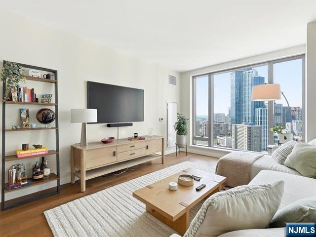 Stop paying luxury rent and start building equity at 99 Hudson, Jersey City's premier luxury waterfront condominium. This stunning 22nd-floor residence offers floor-to-ceiling windows with breathtaking Jersey City and skyline views, wide-plank oak flooring, Bosch appliances, a gas range with vented XO hood, white lacquer Italian cabinetry, spa-inspired baths, and in-unit laundry. Live like you're on vacation every day with over 65,000 square feet of resort-style amenities. The centerpiece is one of New Jersey's largest residential outdoor amenity decks featuring an 80' x 50' swimming pool, hot tub, private cabanas, landscaped green space, outdoor dining areas, BBQ grills, playground, and dog run. Residents also enjoy a state-of-the-art fitness center, yoga and Pilates studio, sauna, steam room, golf simulator, screening room, resident lounges, business center, children's playroom, and 24-hour concierge and doorman service. Perfectly located in Downtown Jersey City's vibrant waterfront district, just moments from the PATH train and NY Waterway Ferry, offering a fast and convenient commute to Manhattan. Enjoy the best of Jersey City luxury living with world-class amenities, stunning views, and unmatched access to New York City.