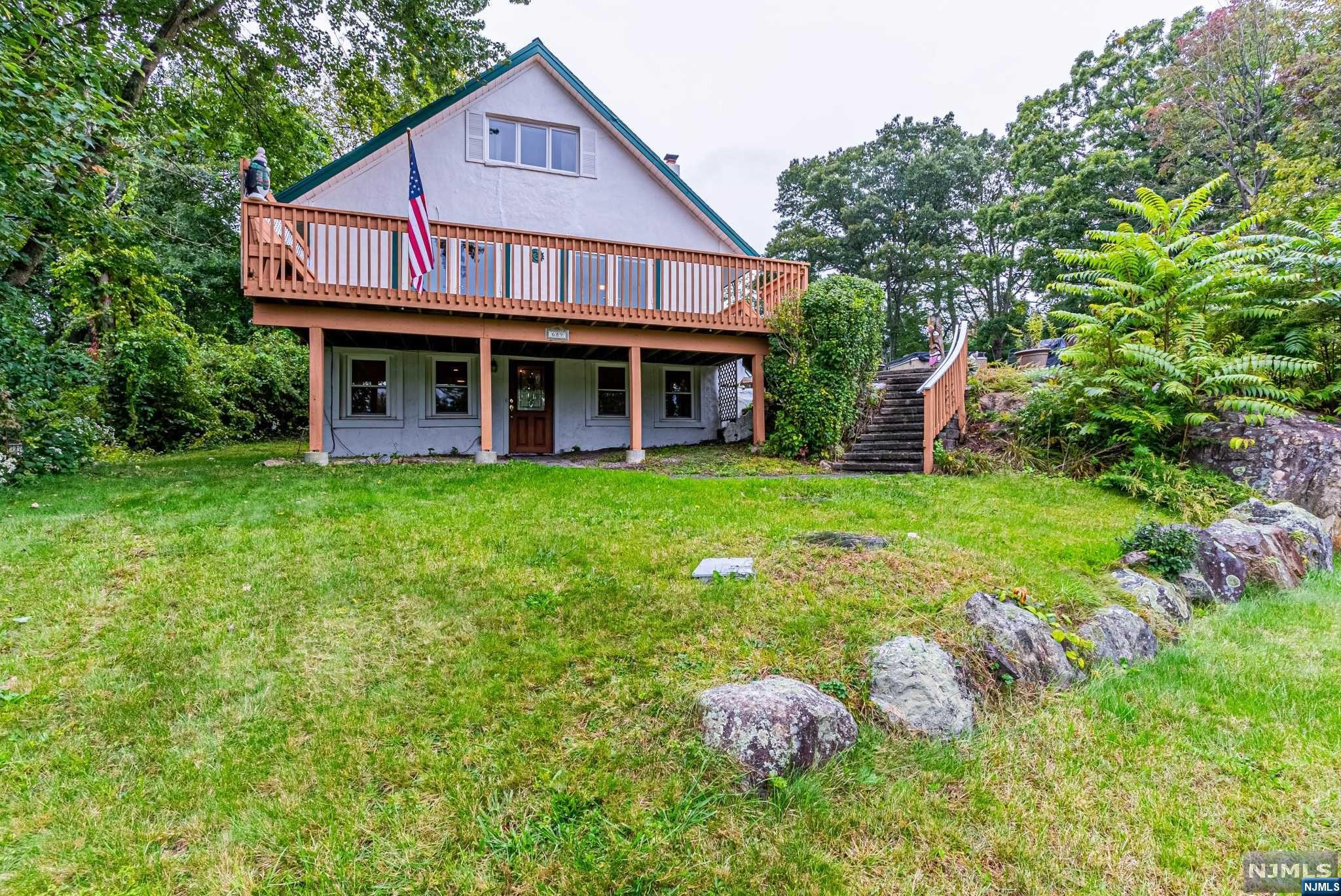 Perched atop a gentle hill, this secluded sanctuary treats you to breathtaking water vistas year-round. Introducing 689 Warwick Turnpike! Impeccably maintained, this residence boasts three bedrooms, an office, gleaming hardwood floors throughout, an updated kitchen complete with a breakfast peninsula, an expansive deck offering uninterrupted water panoramas, your very own private hot tub, a secluded patio, and a state-of-the-art steam furnace. Located just moments from Waywanda State Park, Abraham Hewitt State Park and the Appalachian Trail for the outdoor enthusiasts. This charming town of Warwick is minutes away and you'll be in close proximity to an array of enjoyable pursuits; from apple picking to visits to nearby wineries, breweries, and even a secret speakeasy, your options for entertainment are endless. And there are plenty of activities to keep the little ones engaged or long walks with your four legged friends. Don't miss the chance to make this your new home!