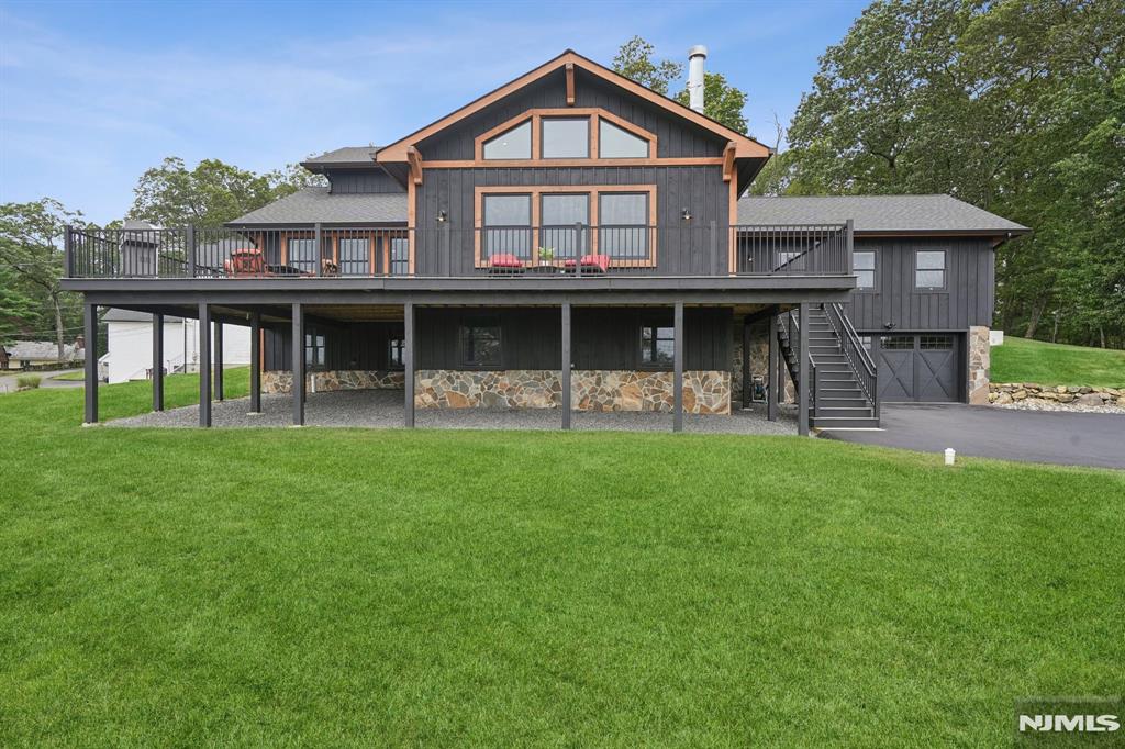 Welcome to this Laketastic custom retreat at 8 Sutton Road in beautiful Hopatcong! Built in 2022, this stunning 3 bedroom, 3 bath home offers approximately 2,900+ sq ft of beautifully designed living space with an open concept layout, soaring cathedral ceilings, and exceptional craftsmanship throughout. Designed for both everyday comfort and entertaining, the spacious living room flows seamlessly into the dining area and gourmet kitchen creating the perfect gathering space. The luxurious primary suite features a walk-in closet and private bath, while additional bedrooms provide flexibility for guests, home office space, or extended living. Enjoy the true Lake Hopatcong lifestyle with seasonal lake views, lake privileges, and outdoor spaces ideal for relaxing or entertaining. The expansive deck overlooks the peaceful setting and offers the perfect place for morning coffee, sunset evenings, and summer gatherings. Situated on a beautiful oversized lot with mature surroundings, this property combines privacy, elegance, and convenience. Whether you are searching for a year-round residence, weekend getaway, or entertainer's dream, this exceptional home captures the essence of Lake living with style, comfort, and timeless appeal.