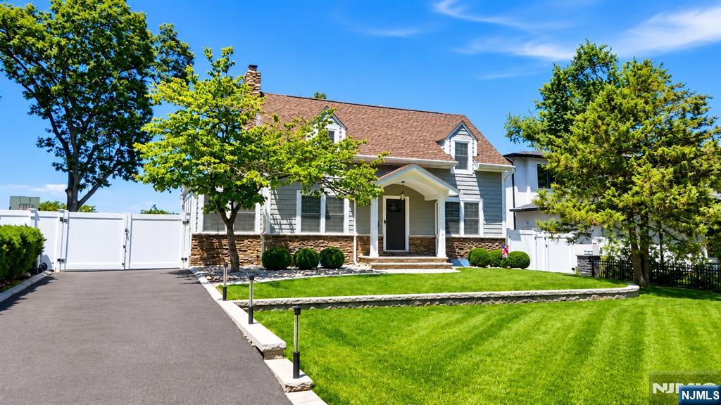 Move-in ready home on one of Paramus's most elevated streets, offering extensive upgrades throughout. Two-tier hardscaping, mature landscape lighting, a covered patio, and parking for approximately five vehicles complement a driveway leading to a detached two-car garage with automatic openers. Oak hardwood floors extend across the first and second levels. The living room includes a gas fireplace. LED recessed lighting is installed on the upper level. The kitchen is equipped with a six-burner range, wall oven, refrigerator, beverage refrigerator, dishwasher, microwave, vented exhaust hood, and pantry. Two-zone HVAC (heating and cooling) with smart thermostats serves the home, supported by a 2022 furnace, 2022 water heater, and Aprilaire whole-house humidifier. A whole-house Generac generator, Aquasana whole-house water filtration system, basement dehumidifier, and updated 200-amp electrical panel complete the mechanicals. Five-zone underground irrigation system services the grounds. The primary suite includes a bath with Mr. Steam steam shower and radiant heated floors, plus an air-conditioned walk-in closet. The hall bath also features radiant heated flooring. The finished basement offers laminate flooring, dedicated heating and cooling, and washer/dryer included. Convenient to Bergen County shopping, dining, and major commuter routes.