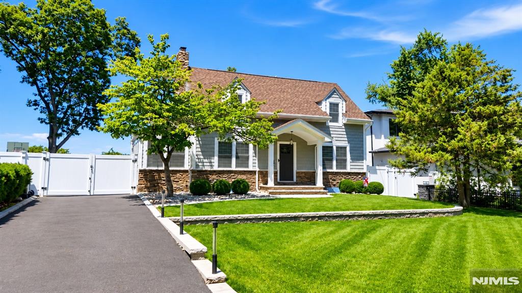 Move-in ready home on one of Paramus's most elevated streets, offering extensive upgrades throughout. Two-tier hardscaping, mature landscape lighting, a covered patio, and parking for approximately five vehicles complement a driveway leading to a detached two-car garage with automatic openers. Oak hardwood floors extend across the first and second levels. The living room includes a gas fireplace. LED recessed lighting is installed on the upper level. The kitchen is equipped with a six-burner range, wall oven, refrigerator, beverage refrigerator, dishwasher, microwave, vented exhaust hood, and pantry. Two-zone HVAC (heating and cooling) with smart thermostats serves the home, supported by a 2022 furnace, 2022 water heater, and Aprilaire whole-house humidifier. A whole-house Generac generator, Aquasana whole-house water filtration system, basement dehumidifier, and updated 200-amp electrical panel complete the mechanicals. Five-zone underground irrigation system services the grounds. The primary suite includes a bath with Mr. Steam steam shower and radiant heated floors, plus an air-conditioned walk-in closet. The hall bath also features radiant heated flooring. The finished basement offers laminate flooring, dedicated heating and cooling, and washer/dryer included. Convenient to Bergen County shopping, dining, and major commuter routes.
