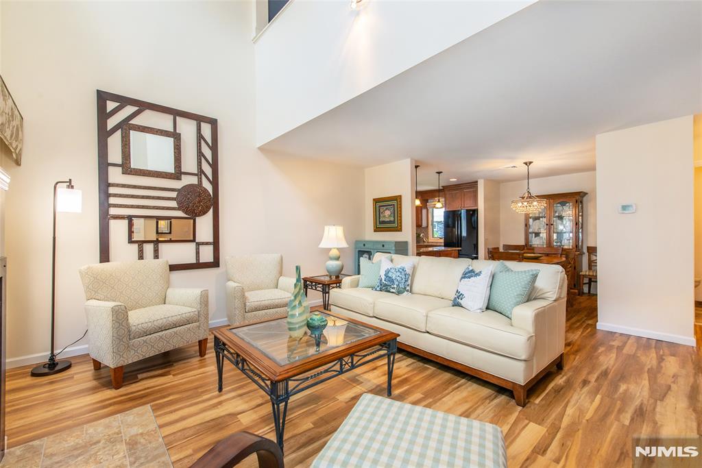 Move right into this beautifully updated 2-bedroom, 1.5-bath top-floor end-unit condo in the desirable River Renaissance community. Featuring soaring vaulted ceilings, an open-concept layout, and numerous recent updates, this home offers the perfect blend of style, comfort, and convenience. Freshly painted in 2023, the home features new flooring (2024) throughout the first floor. The bright living area includes a cozy fireplace, powder room, and sliding doors leading to a deck with low-maintenance Trex decking. The renovated kitchen showcases granite countertops, custom walnut cabinetry, and a new GE refrigerator and dishwasher (2026). Upstairs, the spacious primary bedroom offers double closets, while the loft-style second bedroom, currently used as a den/family room, overlooks the living room below and creates an open, airy feel. The stunning renovated main bath features a custom design, natural quartz countertops, large stall shower and a newer washer and dryer (2022) conveniently hidden behind a closet. Additional highlights include central AC, a tandem two-car garage with interior building access, storage and ample guest parking throughout the community. Conveniently located near parks, shopping, dining, public transportation, and major highways, this home benefits from low HOA fees and is part of a well-maintained community with strong HOA management and a no-pet policy. Stylish, low-maintenance living in a prime location. This one won't last!
