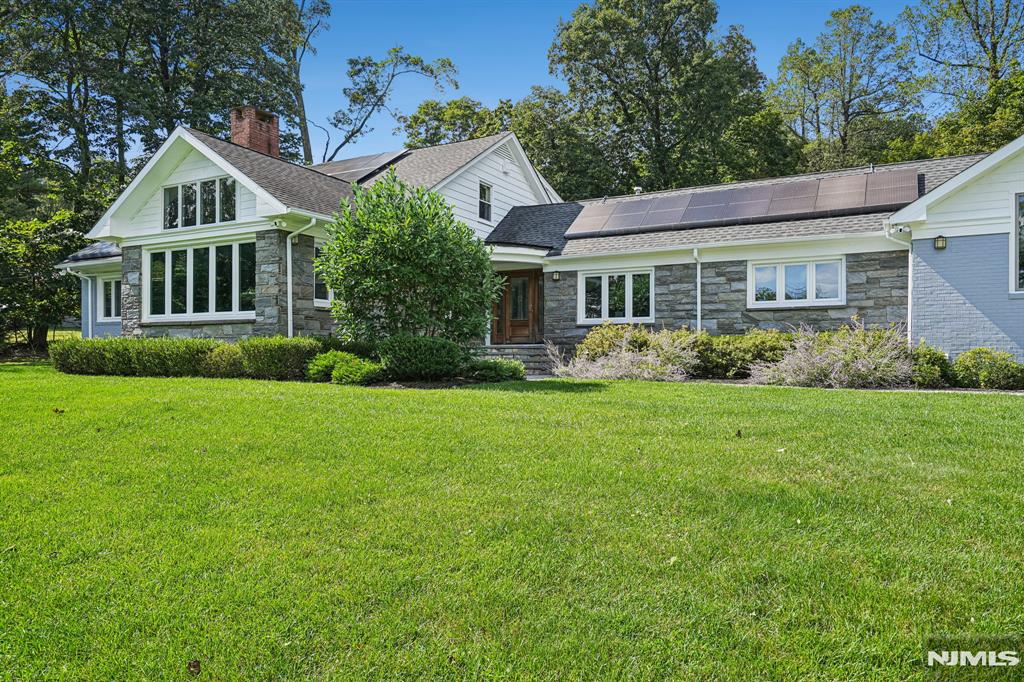 Absolutely stunning, this fully renovated 6-bedroom, 5 full and 2 half bath raised ranch is perched on a hilltop and drenched in natural light, offering tranquility, relaxation, and a seamless connection to nature where everyday living feels like a vacation. The open layout connects expansive living spaces including outdoors, ideal for today's work-from-home lifestyle, This smart home features two solar rooftop systems, all new double-pane windows, and energy-conscious upgrades. The outdoor oasis is unmatched, with a heated in-ground pool, fully equipped pool house with kitchen and full bath, and bluestone patios perfect for dining, lounging, and outdoor movie nights.The formal yet inviting living room showcases dramatic architectural detail, a wall of windows capturing sunrise and NYC skyline sunset views Plans are available for the 3,100 SF basement, where walls, French drains, and five sump pumps are already in place. At the heart of the home is the chef's kitchen and family room, featuring custom Spanish cabinetry, high-end appliances, and a 15' x 6' island with prep sink, wine cooler, and seating for six, plus a separate dining area. A 1st fl laundry rm off the mudroom 3 distinct sleeping/work zones provide flexibility: A 1st fl primary suite w/ fireplace, dressing room, walk-in closet, & bath, plus a 1st fl bedroom w/bath a 2nd-fl south wing - 3 bedrooms and hall bath; a private north wing studio bedroom with its own staircase, bath, and sink. A garage w/ EV charger.