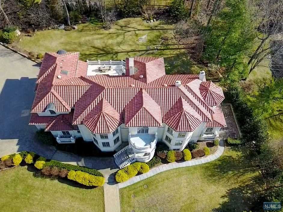 GORGEOUS MEDITERRANEAN COLONIAL SITTING HIGH ON A LUSHLY-LANDSCAPED CORNER PROPERTY IN PRESTIGIOUS ALPINE. BRIGHT, OPEN FLOOR PLAN WITH A GRAND MARBLE FOYER, LIBRARY/GUEST ROOM W/FIREPLACE, BANQUET-SIZED DINING ROOM AND A GOURMET CHEF'S KITCHEN FOR ALL YOUR ENTERTAINING NEEDS. IMPRESSIVE GREAT ROOM W/ VAULTED CEILINGS, ARCHED WINDOWS & FRENCH DOORS THAT OPEN TO A LARGE STONE TERRACE OVERLOOKING NEARLY 1 ACRE OF FLAT YARD. A BUTLER'S PANTRY/MUDROOM & ORNATE FULL BATH COMPLETE THE FIRST LEVEL. UPSTAIRS AMENITIES INCLUDE A LUXURIOUS PRIMARY RETREAT W/SITTING AREA, FIREPLACE, WALK-IN CLOSETS, MARBLE BATH W/STEAM SHOWER, JACUZZI & RADIANT HEATED FLOORS, 3 MORE PRIVATE EN-SUITES. THE WALK-OUT LOWER LEVEL HAS RECREATION W/MEDIA RM, BAR, FITNESS AREA. ALSO 4-CAR GARAGE W/ WIDE PAVERS DRIVEWAY, PROFESSIONALLY-LANDSCAPED PRIVATE GROUNDS. WITH LOW TAXES, PROXIMITY TO MANHATTAN & GREAT SCHOOLS, ALPINE IS TOP-RANKED BY FORBES. NOTHING TO DO BUT MOVE IN AND ENJOY THE BEST OF BERGEN COUNTY!