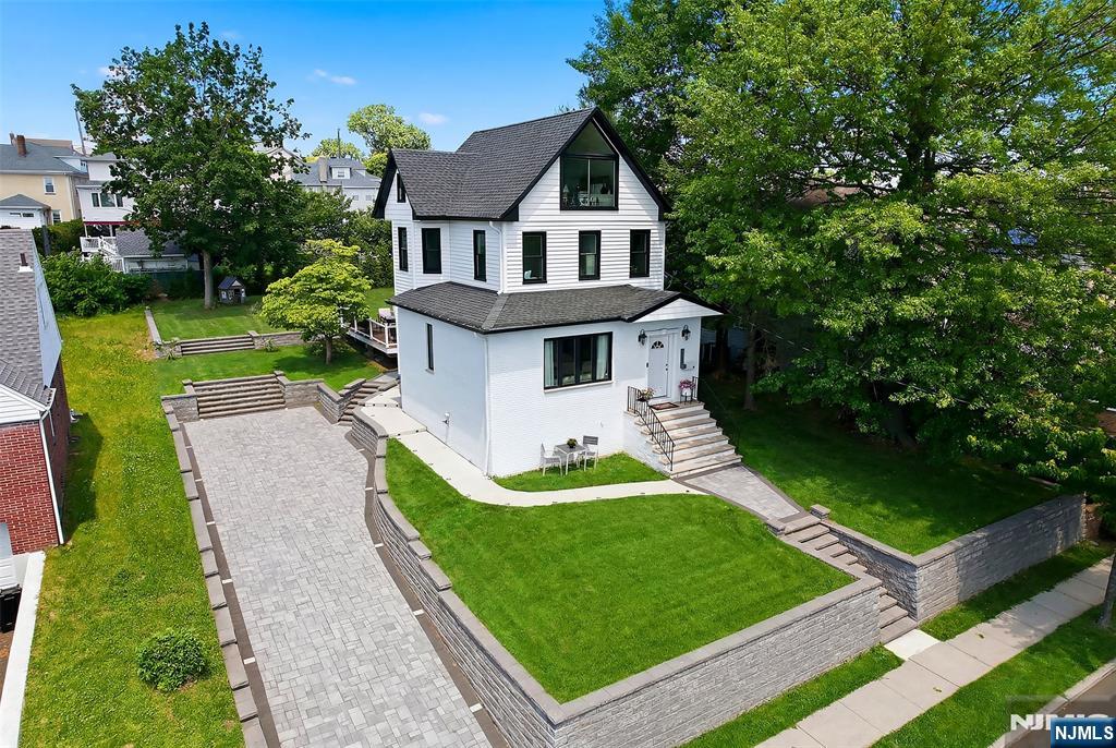 Welcome to this stylishly updated 3-bedroom, 3.5-bath Colonial, perfectly situated on a deep, lushly landscaped lot in one of the area's most desirable towns. Designed for both comfortable living and effortless entertaining, this exceptional home offers a seamless blend of classic charm and modern updates. The spacious interior features a bright inviting living room leading to a large formal dining room, great for gatherings! The second floor features 2 bedrooms, one full bath as well as a bonus room, great for an office or nursery. The third floor boasts a stunning primary suite with a full bath and breathtaking NYC views. A fully finished basement with a full bath provides valuable additional living space, ideal for a recreation room, home office, gym, or guest accommodations. Step outside to your private backyard oasis, where the expansive lot and Trek deck offer endless possibilities for outdoor gatherings, dining, and relaxation amid beautiful mature . Conveniently located near schools, parks, shopping, dining, and transportation, this move-in-ready home combines style, space, and an unbeatable setting in a highly sought-after community.