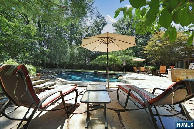 Stunning Englewood Contemporary with Breathtaking Views! Perched high on the hill, this 4-bedroom, 4-bath home offers sweeping western views and a beautifully renovated open floor plan. The backyard is a private oasis with a heated gunite pool, outdoor kitchen with BBQ, play area, and wooded surroundings. Inside, natural light fills every room. The living, dining, and family areas flow seamlessly, anchored by a gas fireplace. The chefâ€™s kitchen features granite countertops, Wolf appliances, and direct access to the backyard. The primary suite includes a fireplace, spa-like bath, two walk-in closets, and a private deck. A separate wing currently serves as an office but is ideal for a guest suite. Just 6 miles from NYC, near shopping, dining, and houses of worshipâ€”this home is perfect for entertaining and everyday living!