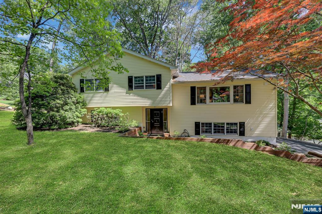 Beautifully Expanded 4-BR Home on Nearly an Acre in River Vale! Set on lush, professionally landscaped property, this beautifully updated home offers space, style, and exceptional indoor-outdoor living. Step into the welcoming foyer leading to a large family room with a charming brick fireplace, convenient laundry room, and half bath.  Upstairs, the bright and open living room flows seamlessly into the large dining room, creating the perfect setting for entertaining. The stunning modern eat-in kitchen features white cabinetry, Quartz countertops, stainless steel appliances, radiant heated floors and a spacious dining area with a wall-of-windows and sliding doors to the deck. Just a few steps up, you'll find the large primary suite featuring two closets and an updated full bath. Two additional spacious bedrooms and an updated full bath complete this level. The lower level offers a versatile bonus room that can serve as fourth bedroom, home office or gym, along with ample storage space and direct access to the garage. Outside, enjoy your own private retreat on nearly an acre of beautifully landscaped grounds. The expansive backyard features a large paver patio and spacious deck, providing the perfect backdrop for entertaining, relaxing, and enjoying the outdoors. A rare opportunity to enjoy space, privacy, and modern updates in one of River Vale's most desirable locations!
