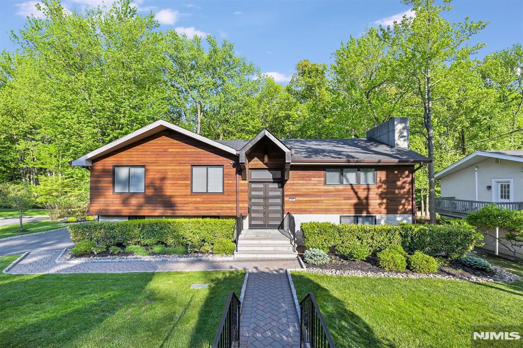 Welcome to this beautifully designed 5-bedroom, 4 full bath North Cliffs home! The open-concept layout features a living room with a modern gas fireplace and a stunning kitchen with a Thermador range. The main level offers a luxurious primary suite with a custom walk-in closet and spa-like bath, along with two additional bedrooms and a full bath. The lower level opens to the private, professionally landscaped property with a sprawling patio, perfect for entertaining. This level includes a spacious family room, gym or bedroom, full bath, guest suite, and direct access to the 2-car garage. Notable features include a Brazilian teak and limestone veneer exterior, Nest thermostats, whole-house dehumidification, updated plumbing and electrical, LED recessed lighting, hardwired fire alarm system, gas generator (2026), and hot water system (2025). Smart home automation controls lighting, climate, sprinkler system, alarm, doorbell cameras, garage doors, generator, and Hunter Douglas remote blinds. Ideally located in the coveted North Cliffs, just moments from NYC, fine dining, tennis courts, the town park, and North Cliffs School. Just move right in to this turnkey home.