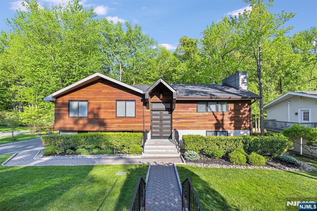 Welcome to this beautifully designed 5-bedroom, 4 full bath North Cliffs home! The open-concept layout features a living room with a modern gas fireplace and a stunning kitchen with a Thermador range. The main level offers a luxurious primary suite with a custom walk-in closet and spa-like bath, along with two additional bedrooms and a full bath. The lower level opens to the private, professionally landscaped property with a sprawling patio, perfect for entertaining. This level includes a spacious family room, gym or bedroom, full bath, guest suite, and direct access to the 2-car garage. Notable features include a Brazilian teak and limestone veneer exterior, Nest thermostats, whole-house dehumidification, updated plumbing and electrical, LED recessed lighting, hardwired fire alarm system, gas generator (2026), and hot water system (2025). Smart home automation controls lighting, climate, sprinkler system, alarm, doorbell cameras, garage doors, generator, and Hunter Douglas remote blinds. Ideally located in the coveted North Cliffs, just moments from NYC, fine dining, tennis courts, the town park, and North Cliffs School. Just move right in to this turnkey home.