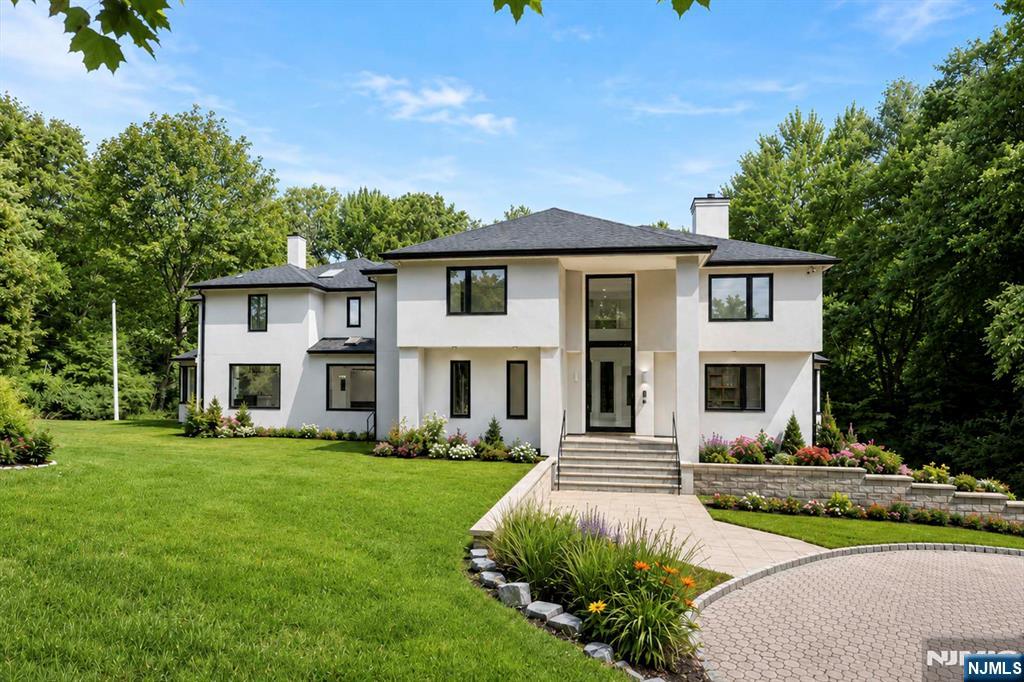 Renovated to perfection in 2024, this home features soaring ceilings and expansive walls of glass that showcase the stunning, flat 1.9 acre property. The residence feels brand new, with every detail meticulously updated including luxurious new bathrooms, a state-of-the-art kitchen, elegant stone floors, rare wood, custom doors & giant modern windows. The design embraces a sleek, minimalist aesthetic with spacious, dramatic rooms. The enormous master suite boasts a large custom wardrobe room and multiple fireplaces add warmth and charm. The property also includes an oversized 3-car garage and smart home technology. Enjoy the tranquility of Lambs Lane in Cresskill! The virtual tour link for this listing features a comprehensive video tour, a 3d model that covers all 3 levels, and floor plans. https://njproper.com/mls-1-lambs