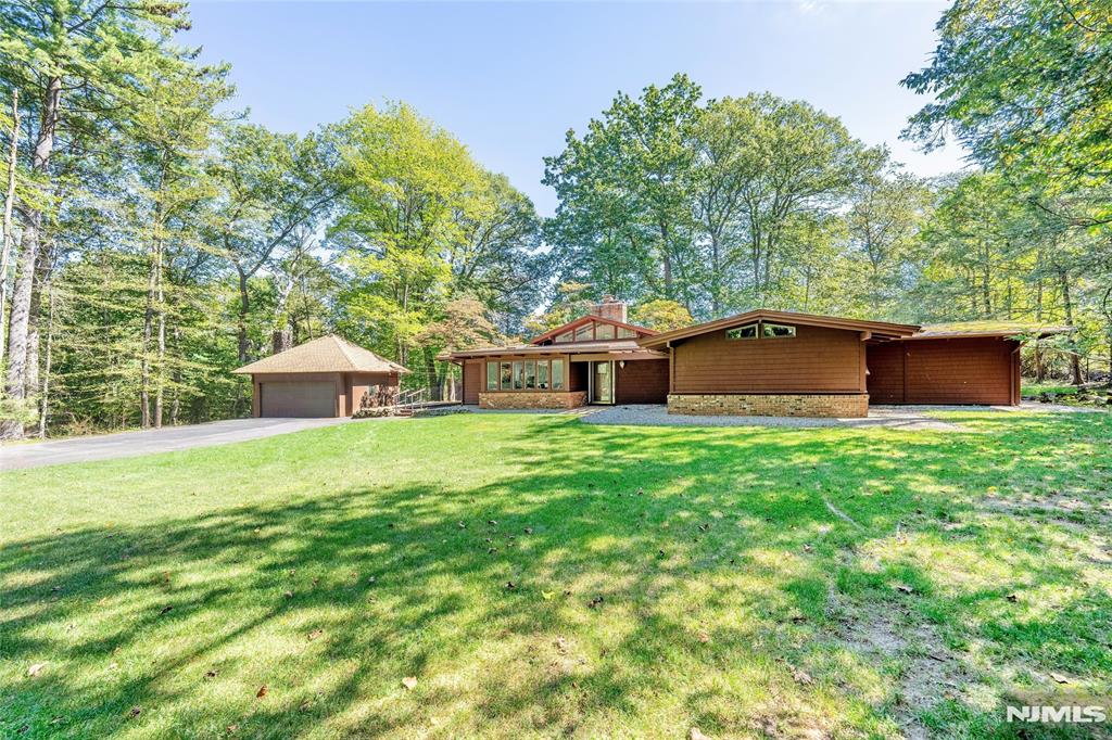 COME EXPERIENCE THIS MOVE-IN CONDITION, FRANK LLOYD WRIGHTâ€“INSPIRED CUSTOM CONTEMPORARY RANCH â€” A DESIGN-FORWARD HOME PERCHED ON A PRIVATE, SCENIC .95-ACRE WOODED PROPERTY WITH A RECENTLY RENOVATED HEATED GUNITE POOL WITH WATERFALL, PATIO & CUSTOM STONEWORK. OPEN, LIGHT-FILLED FLOOR PLAN WITH VAULTED BEAMED CEILINGS, EXPANSIVE WINDOWS, SKYLIGHTS & DRAMATIC HARDWOOD FLOORS THROUGHOUT. MAIN LEVEL: ENTRY FOYER, FORMAL DINING RM, MODERN EAT-IN KITCHEN WITH GRANITE COUNTERTOPS, CUSTOM CABINETRY & SUNLIT WINDOWED DINING AREA WITH DRS TO SIDE YARD, STEP UP TO LG GREAT RM WITH RECENTLY RENOVATED FIREPLACE IDEAL FOR ENTERTAINING OR EVERYDAY LIVING, PRIMARY BR SUITE FEATURES A NEW FLOOR-TO-CEILING ATRIUM, DRS TO POOL AREA & LUX BATH WITH JACUZZI & SEP SHOWER, 2 ADDITIONAL GENEROUS BRâ€™S & FULL HALL BATH. GROUND LEVEL: FLEXIBLE 4TH BR/OFFICE/MEDIA OR THEATER SPACE PLUS SPACIOUS LAUNDRY RM. BASEMENT: PARTIALLY FINISHED, WITH SUBSTANTIAL STORAGE & UPDATED HEATING, AIR CONDITIONING & HOT WATER SYSTEMS. DETACHED 2-CAR GARAGE WITH ATTIC STORAGE. CONVENIENT TO SCHOOLS, SHOPPING & PUBLIC TRANSPORTATION WITH QUICK ACCESS TO MANHATTAN â€” OFFERING PRIVACY, STYLE & EVERYDAY LIVABILITY, IDEAL FOR FAMILY LIVING OR ANYONE WHO APPRECIATES A SPECIAL ARCHITECTURAL SETTING. A RARE ARCHITECTURAL HOME BLENDING MODERN COMFORT, NATURAL BEAUTY & TIMELESS DESIGN.