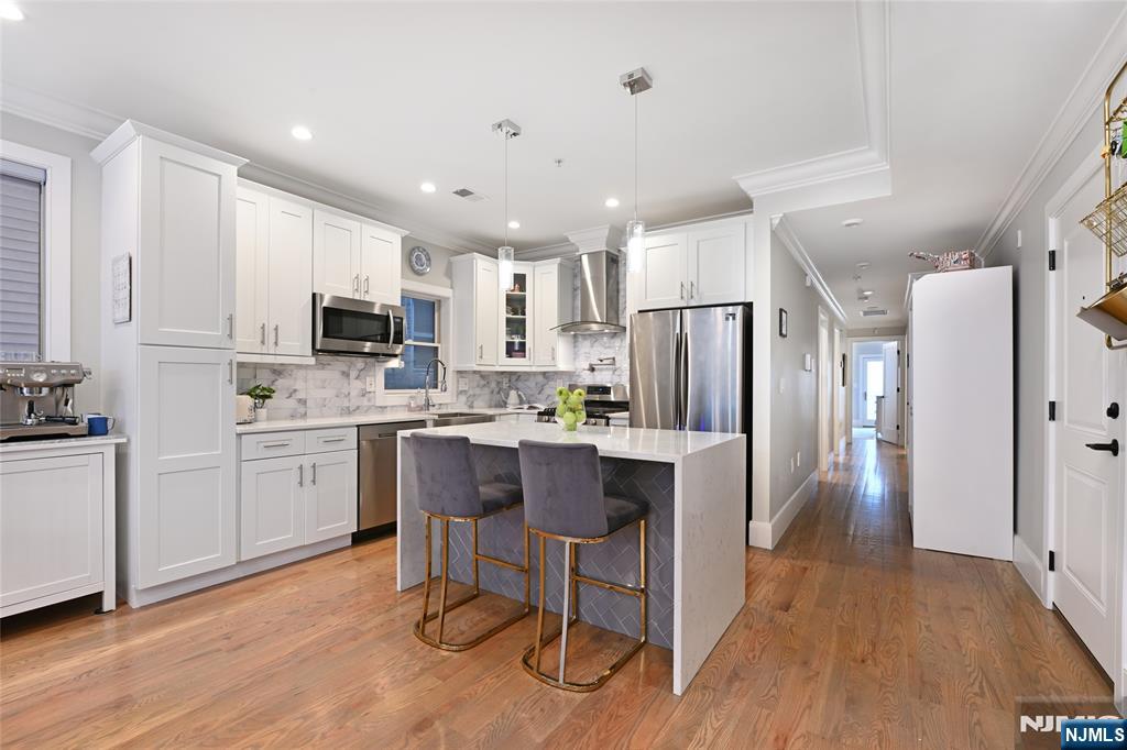 Discover modern luxury at 61 Skillman Ave #2A in Jersey City. This stunning 3-bedroom, 2-bathroom residence offers a perfect blend of style, comfort, and convenience. Step inside and be greeted by an open-concept living area, bathed in natural light and featuring gorgeous hardwood floors that flow throughout the home. The chef-inspired kitchen is a culinary enthusiast's dream, boasting sleek Samsung appliances, stylish shaker cabinets, and a striking two-tone waterfall island â€“ perfect for gathering and entertaining. Relax and unwind on your private terrace, a true urban oasis. The primary bedroom is a sanctuary of its own, complete with an ensuite bathroom featuring a stand-up glass-enclosed shower. Two additional well-appointed bedrooms offer versatility for guests, a home office, or a growing family. This meticulously crafted home offers a lifestyle of effortless elegance. This home offers easy access to transportation, parks, restaurants, and shops.