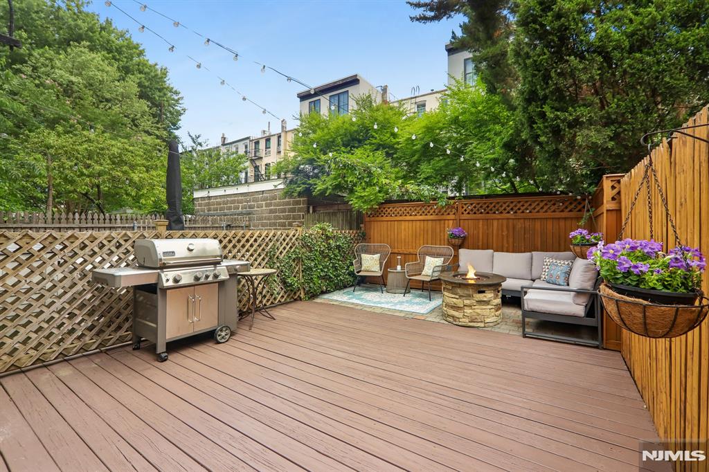 Welcome home to this bright and beautifully maintained 2-bedroom, 2-bath residence, ideally situated on the parlor level of a charming, tree-lined Park Avenue block. This inviting home combines classic character with modern updates, featuring hardwood floors, soaring ceilings and an elegant fireplace mantel. The open-concept kitchen flows seamlessly into the living area and is appointed with granite countertops, a breakfast bar, stainless steel appliances, a dishwasher, and the convenience of an in-unit washer and dryer. The spacious primary suite offers ample room to unwind, while the second bedroom is perfect for guests or a home office, with a full bath conveniently located just outside the door. Step outside to your own private backyard oasisâ€”perfect for summer entertaining, grilling, or simply relaxing. The recently refinished deck looks brand new and creates an ideal outdoor retreat. Additional amenities include a private storage cage and a common bike room in the basement. Located just steps from vibrant Washington Street, restaurants, shopping, parks, and NYC transportation, this move-in-ready home offers the perfect blend of comfort, convenience, and outdoor living. Enjoy the best of summer in your new home!