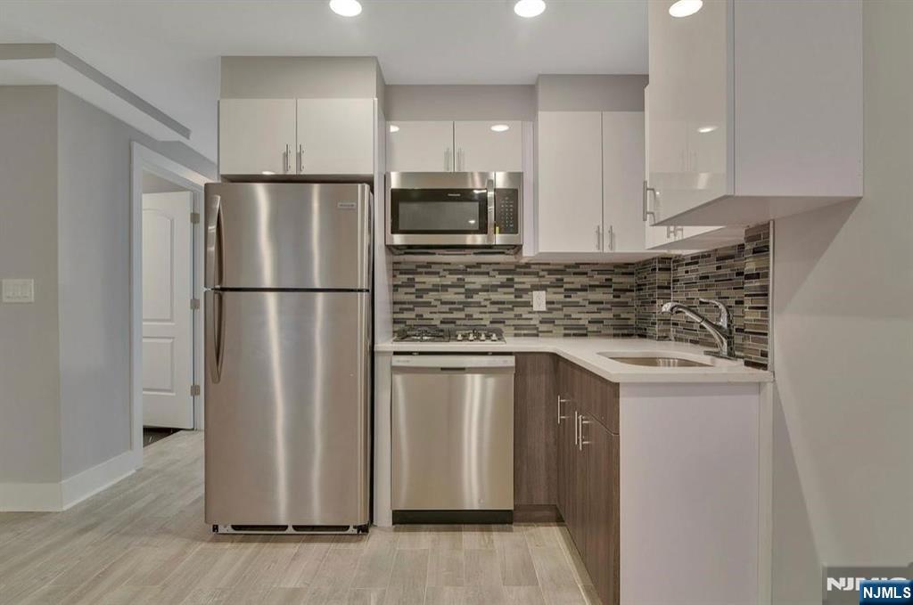 Extraordinary investment and lifestyle opportunity located just moments from the Grove Street PATH station in Jersey City. This 4-unit residence has been completely gut-renovated, offering a flawless fusion of historic architecture and modern luxury. Behind the preserved historic façade, each residence features premium finishes and high-end appliances. Residents also enjoy a rare shared backyard and garden, providing a private urban oasis. Positioned in the vibrant downtown district, the property is surrounded by premier dining and shopping, with unobstructed views of the Manhattan skyline. This property is a high-performing asset in a blue-chip location, offering strong rental income and exceptional appreciation potential. Whether you choose to occupy a unit or manage it as a full investment, this residence delivers value on every level. Opportunities of this caliber in such a premier location are rare.