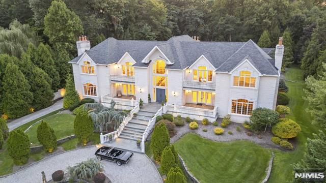 Le Palais of Saddle River. Over 10,000 sq ft of luxurious space greeted by a 2 1/2 story foyer featuring Italian ironwork on its stunning bridal staircase. The ballroom impresses w/ soaring 24-ft ceilings w/ extensive wood trim, 3-ft corbels, and 2 imported crystal chandeliers. The new GCEIK is a culinary dream, equipped w/ 60" Wolfe range and Miele appliances, completed w/ Soho-style open ceiling rafters, Waterstone faucets and Calacatta marble. The 14-seat frml DR is perfect for all affairs. A primary suite w/ cozy sitting area, oversized WIC, and all-marble bath enjoys a private terrace as well. 4 additional en-suite BDRMs 1 w/ spiral staircase to a private loft and another w/ a terrace is perfect for families and guests alike. Additional highlights include a home theater, a dedicated gym, and a seven-car garage. Outside the heated free formed gunite pool w/ a stunning 8' waterfall, surrounded by a bluestone patio and an outdoor cabana perfect for entertaining: WATCH VIDEO TOUR