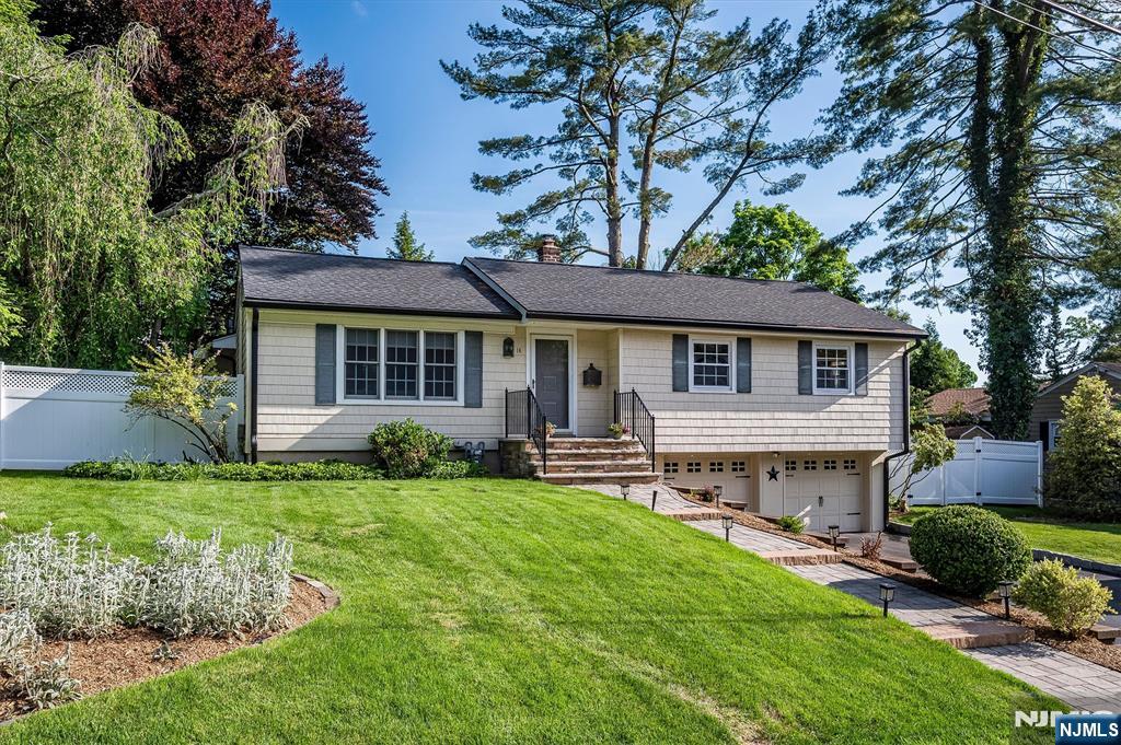 Move right into this beautifully maintained 3-bedroom, 3-bath ranch, nestled on a picturesque tree-lined street. Designed for comfortable everyday living and effortless entertaining, the bright interior features spacious living and dining areas, an open kitchen with banquette seating, and abundant natural light throughout. The heart of the home is the expanded family room, where soaring ceilings, Palladian windows, and a gas fireplace create a warm and inviting gathering space. Step outside to a generous deck overlooking a large, private backyard enclosed by a white vinyl privacy fenceâ€”perfect for outdoor dining, gardening, recreation, or simply relaxing with family, friends, and pets. The lower level offers flexible space for recreation, a home office, or a fitness area, along with a laundry room and ample storage. Notable improvements include an architectural shingle roof, oversized 6-inch gutters, a paver walkway, a repaved driveway, and a two-car garage equipped with a 240-amp electric outlet for EV charging. Offering the ideal balance of suburban living and commuter convenience, this wonderful home is just minutes from top-rated schools, shopping, dining, parks, and NYC transportation, providing a lifestyle of comfort, convenience, and connection.
