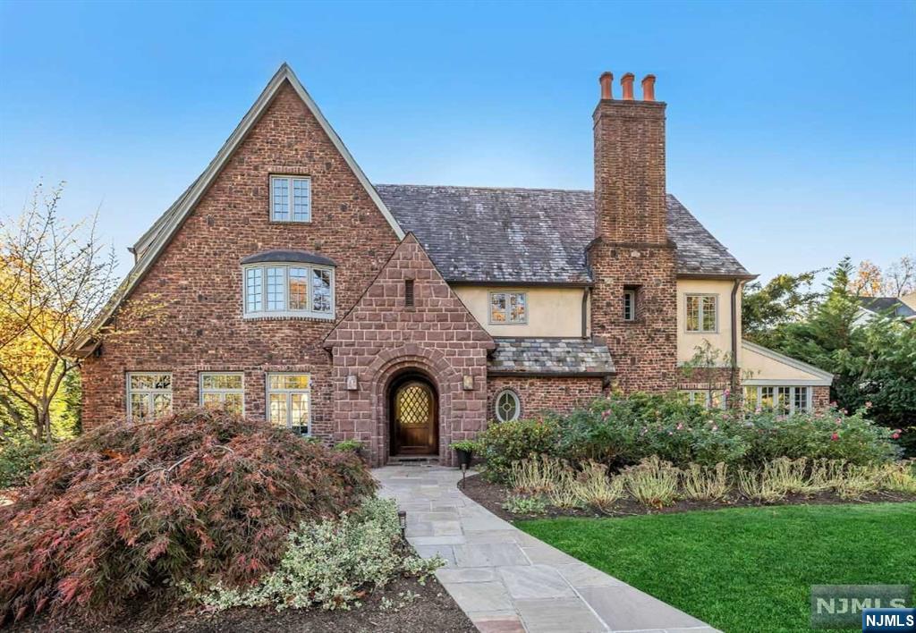 Pristine, masterfully renovated and expanded in 2007, English Tudor in Ridgewood's sought-after Old Country Club neighborhood. Nestled on 0.54 acres, this exquisite 5-bedroom (+ bonus room), 4.5 baths masterpiece boasts unsurpassed quality, timeless style & modern conveniences. The grand arched Brownstone entry welcomes you to a light-filled interior with open, seamless functional flow. At the heart of the home is a designer kitchen with breakfast room and family room with stone fireplace and coffered ceiling. French doors lead to a large stone patio with fireplace for outdoor living. Gracious dining room and living room with fireplace add to the home's entertainment appeal. Study, butler pantry, mudroom, 2 powder rooms complete the 1st level. Upstairs you'll find a primary suite with vaulted ceilings & French doors to a deck overlooking the flat, private, South-facing backyard oasis. 2-car garage offers an attached vaulted rec space with climbing wall. A truly exceptional home.
