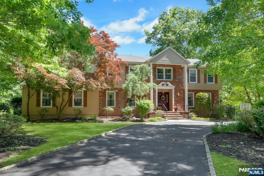 Welcome to 10 Moonshadow Ct, a distinguished Colonial tucked at the end of a private cul-de-sac just off coveted Denise Drive, one of Kinnelon's most desirable residential locations. Surrounded by mature trees and a peaceful wooded backdrop, this expansive home offers privacy, flexibility, and timeless appeal. A dramatic two-story foyer welcomes you into a thoughtfully designed floor plan featuring generously sized living and entertaining spaces. The heart of the home is the expansive great room, flowing seamlessly into the kitchen, dining area, and sun-filled solarium, creating an inviting setting for everyday living and entertaining. The main level includes a bedroom, full bath, and laundry room, providing exceptional flexibility for guests and a convenient first-floor living option. Upstairs, the spacious primary suite serves as a private retreat and is complemented by two additional bedrooms and a dedicated office, ideal for today's work-from-home lifestyle. The finished lower level offers versatile space for recreation, fitness, media, hobbies, or play. Outside, an expansive deck overlooks the private backyard and wooded surroundings, creating a peaceful setting for outdoor dining and entertaining. An in-ground pool offers the opportunity to create your own outdoor retreat. Combining timeless Colonial architecture, exceptional living space, and a sought-after location, 10 Moonshadow Ct offers the comfort, privacy, and flexibility to enjoy for years to come.