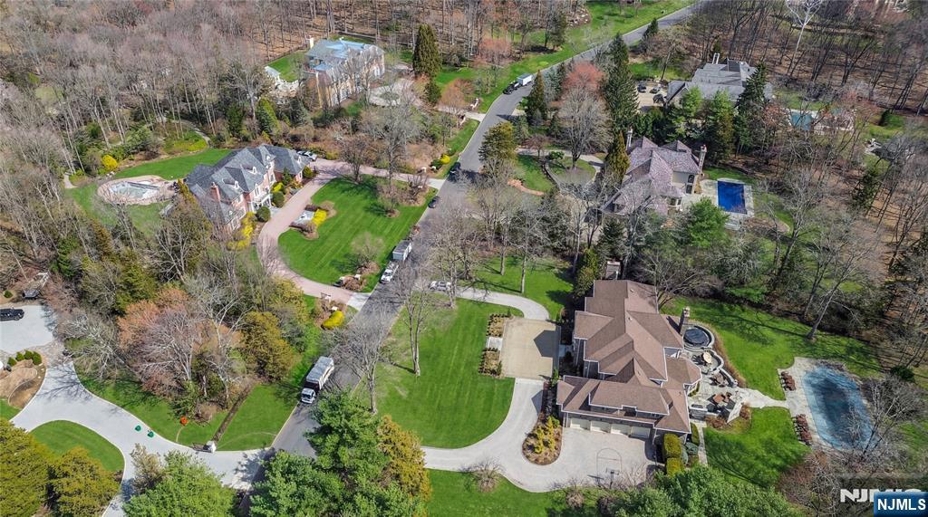 This exceptional estate is on a prime Saddle River location, offering a lifestyle where luxury & convenience meet the quiet confidence. A circular drive leads to a stately entrance and a grand 2 story foyer, highlighted by a sweeping staircase and carefully curated details. *NEW ROOF 2021, BOILERS 2022, HOT WATER TANKS 2024, Front Yard Landscaping Renv 2022 * * THE MAIN LEVEL is thoughtfully designed for both elegant entertaining and everyday living. Formal spaces transition seamlessly into a richly appointed library w/fireplace, while the dining room flows into the kitchen. The great room is filled w/natural light and anchored by a fireplace, creating a warm yet elevated setting. The kitchen is outfitted with a large center island, custom cabinetry and sunlit breakfast gallery overlooking the grounds. A guest bedroom, full bath, powder room, laundry room, second staircase, & access to a 4 car garage complete this level. * * THE 2nd FL offers a spacious primary suite w/a private sitting area, 2 walk in closets, & a well appointed bath featuring a double vanity, soaking tub, & separate shower. 4 additional bedrooms, each with ensuite baths and walk in closets, are thoughtfully arranged w/an additional staircase for convenience. * * THE LOWER LEVEL presents Golf swing suite w/lg glass gallery, expansive space for recreation, media, fitness along w/a full bath & generous storage. * * OUTDOOR LIVING is equally impressive w/custom patios, a heated pool, spa, and outdoor kitchen.