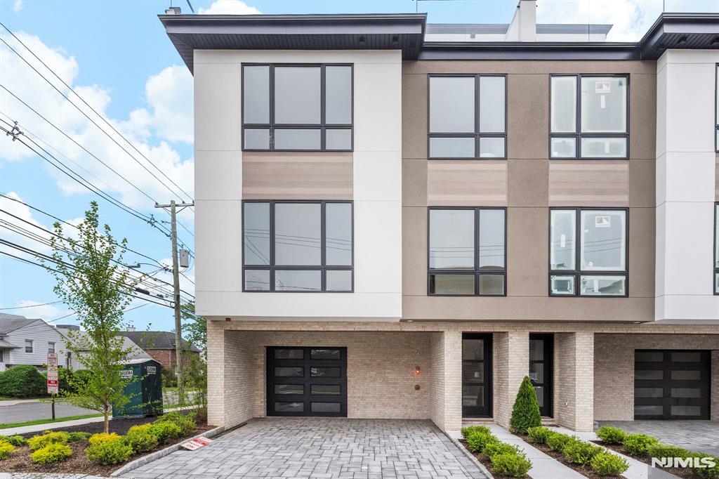 Live stylishly in this bright modern and beautifully designed 4 level townhome featuring 4 spacious bedrooms 4 full bathrooms and 1 half bath expertly crafted for flexible living effortless entertaining and laid-back luxury tucked on a quiet tree lined street this home offers the perfect balance of space style and smart design for how you live today. The main level shines with soaring 10-foot ceilings oversized bay windows and cozy fireplace that add warmth and sophistication The stunning open-concept kitchen is a showpiece complete with a waterfall island sleek two-tone cabinetry , flush high-end appliances that blend seamlessly into the modern layout ideal for both everyday meals and hosting in style. Enjoy the leisure of an office space, ideal work-from-home setup. Upstairs the third level features three generously sized bedrooms including a dreamy primary suite with a spa-like bathroom featuring a soaking tub radiant heated floors dual vanity and a walk-in glass shower A second full bath and a dedicated laundry room add convenience. Head to the top floor your ultimate hangout space with a large rec room. Here find direct access to a walk-out rooftop terrace with glass railings and sweeping Fort Lee views perfect sunset or sunrise. You can also find a large sized bedroom and full bath perfect for guests The ground level features a guest suite , full bath , additional rec space garage. All just minutes to NYC, the GWB, and convenient local transit.