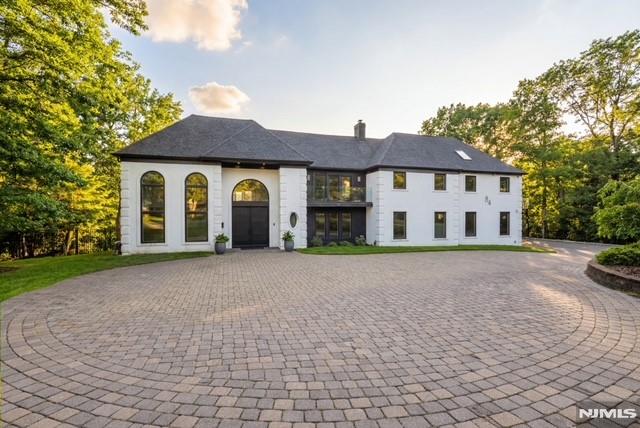 Elegantly designed Contemporary masterpiece showcasing exceptional craftsmanship and impressive scale throughout. A dramatic two-story entry foyer opens to a professionally designed curved glass staircase. Continue onto a soaring two-story living room with cathedral ceilings and an elevator that leads directly up into your 1400 sqft resort style primary suite. Custom moldings and quality hardwood floors enhance the home's refined character. The oversized, state-of-the-art eat-in kitchen is equipped with custom cabinetry, granite countertops, a 20ft. center island with sink, top-of-the-line appliances, a spacious breakfast area, butler's pantry, and built-in glass wine rack. Sliding glass doors lead to a private backyard with deck, ideal for indoor-outdoor entertaining. The expansive finished basement offers a second living space, bedroom suite, laundry room, and walk-out directly to backyard. Meticulous attention to detail throughout. Offering roughly 10,000 square feet of gracious living space, this exceptional residence is ideally located in the highly desirable neighborhood of Livingston, NJ.