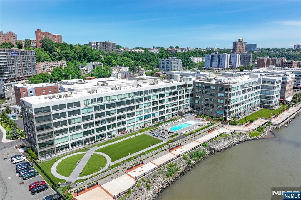 Spacious Luxury 1-Bedroom with Spectacular NYC Skyline Views. Experience over 1,000 sq. ft. of luxurious living with breathtaking floor-to-ceiling views of the Manhattan skyline from every room. this sophisticated residence features 10-foot ceilings, a modern sliding glass barn door, designer finishes, luxury flooring, custom cabinetry, premium countertops, and elegant tile work throughout. The gourmet kitchen is equipped with top-of-the-line Bosch, Wolf, and Sub-Zero appliances, making it ideal for both everyday living and entertaining. Enjoy the convenience of a fully automated smart home system with integrated security, lighting, and climate control. Residents enjoy exceptional resort-style amenities, including a fitness center, outdoor pool, rooftop deck with panoramic views, residentsâ€™ lounge, media screening room with flat-screen TV, and a service bar with refrigerator and sink. Ideally situated just steps from the waterfront, parks, fine dining, boutique shopping, and easy transportation to Manhattan. One indoor garage parking space is included.