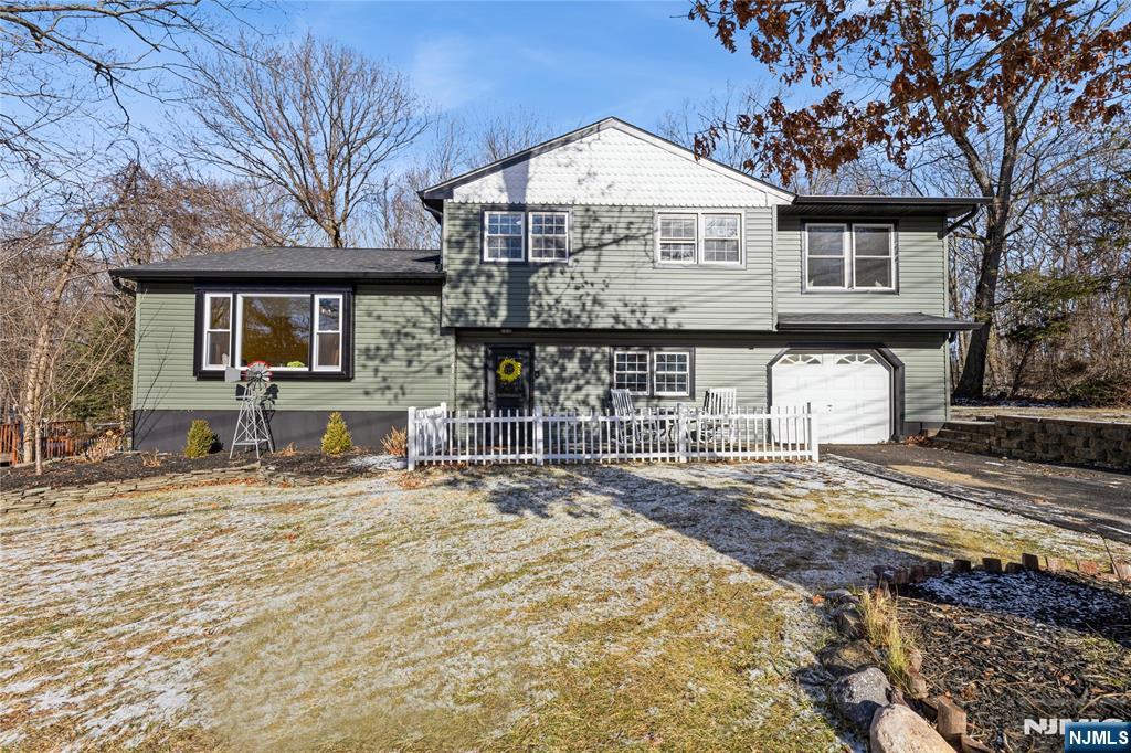 Move right into this stunning 4-BR, 2-BA split-level home with a 1-car garage on a private lot less than 5 miles from Greenwood Lake. Renovated from 2020-2024, this home blends modern upgrades with timeless charm. The LL features a foyer, coat closet, pantry, FR with bar, wood-burning stove, updated BA, new sliders to the patio, and garage access. The main level boasts a bright LR, DR, and remodeled kitchen with wood-look tile floors, SS appliances, cathedral ceiling, skylight, and sliders to a large screened-in deck (2024) overlooking the private backyard. The 2nd floor has 4 BRs with updated lighting, new hardwood floors, and an updated BA with vaulted ceilings, skylight, and double sinks. The primary BR stands out with floor-to-ceiling hardwood and an electric fireplace. The finished basement offers a versatile rec room with recessed lighting, next to the laundry/utility room. Key updates: roof & septic (2020), driveway (2023), front door, siding, gutters, and baths (2024). Close to schools, ShopRite, and NYC transportation!