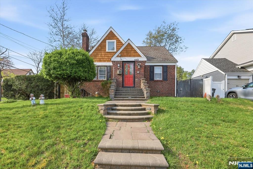 Classic 1943 Cape Cod charm meets timeless curb appeal in this character-rich single-family home nestled in one of Englewood's most established residential neighborhoods. The striking cedar shake upper facade, red brick lower exterior, and bold red entry door give this home an instantly memorable presence, a true head-turner from the street. Set on a 5,998 sq ft lot (approx. 0.14 acres), the home offers 1,215 sq ft of living space across a well-proportioned layout with a dormer-style upper level and classic steep-gabled roofline. A sweeping multi-tiered bluestone and paver walkway leads to a gracious raised entry, an architectural detail that adds both character and elevation to the property's streetscape. Located in the R-E residential zone of Englewood City, Bergen County, this address offers the best of suburban living with unmatched metro access. Minutes to Route 4, I-95, and the George Washington Bridge, with NJ Transit bus service nearby. Englewood's vibrant downtown along Palisade Avenue offers acclaimed dining, boutique retail, and cultural institutions including Bergen PAC. Served by PSE&G gas and electric. Parking on site. Surrounded by mature trees, established landscaping, and a lush, level lawn, all just 12 miles from Midtown Manhattan. A rare opportunity to own a piece of Bergen County history
