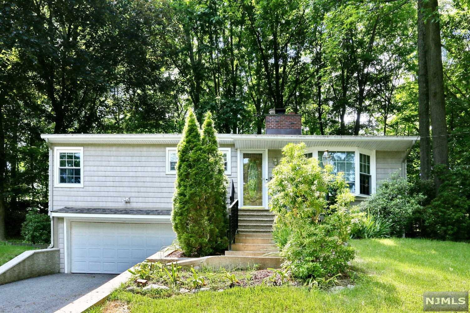 Lovely ranch home. Dual fireplace in living room and dining area. Kitchen has stainless steel appliances. Sunroom/family room overlooks private wooded yard and patio area. Primary bedroom has a half bath. Two other bedrooms and full bath. Full basement with laundry area and access to a two car garage. Hardwood floors. Central air. Convenient to schools, shopping and NYC transportation. Home is in Midland Park but has a Ridgewood mailing address.