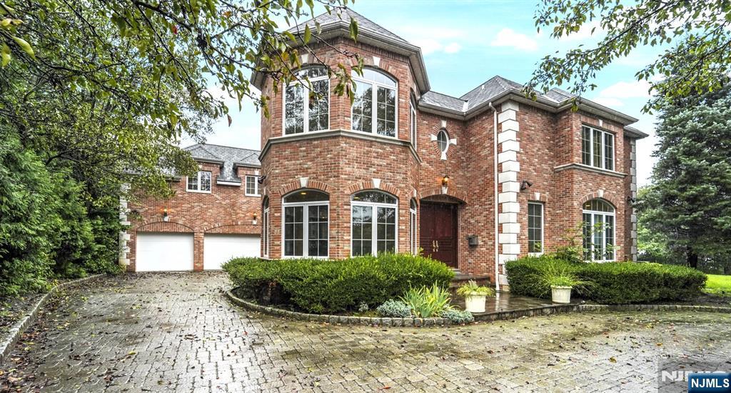 Located in Fort Lee's desirable Bluff section, this expansive 5 bedroom, 7.5 bath center hall colonial is situated along the Palisades Cliffs w/NYC & Hudson River views from almost every room. Over-sized property. 2-story entry foyer. Open layout w/windows along the entire back of the home highlighting the views! 1st floor features a home office w/gas fireplace, family rm, DR, gourmet EIK w/granite countertops, SS Viking appliances & wine fridge, full bath, laundry room & formal LR w/fireplace. Attached 3 car garage. Large MBR suite w/sitting room, fireplace, large full bath, 2 enormous walk-in closets & dressing area. 3 additional BRs each w/full baths. Huge finished basement offers an office, rec room, additional BRs, and 3 more full baths. At approximately 5,500 sq. ft., this home offers a private oasis with quick & easy access into NYC.