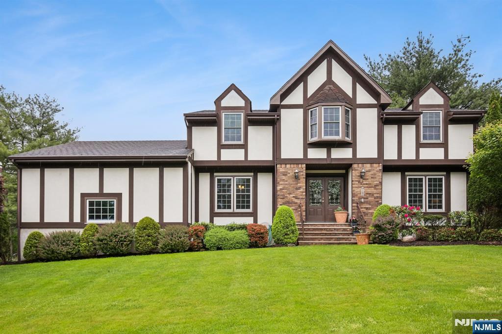 Impeccable Tudor Colonial in desirable Evergreen Estates! Set on a beautifully manicured private lot with a flat backyard, this spacious 4 bedroom, 2.1 bath home offers a classic floor plan ideal for both everyday living and entertaining. Features include hardwood floors, crown molding, formal dining room, bright living room, and an inviting family room with large brick fireplace. Updated kitchen with stainless steel appliances, gas range, granite countertops, and access to an expansive deck with canopy for shaded outdoor enjoyment. Convenient first-floor laundry and powder room. Second level offers 4 generously sized bedrooms, including a primary suite with walk-in closet and ensuite bath. Large unfinished basement provides endless possibilities for additional living space, home office, gym, or recreation area. These original owners have updated and maintained this home throughout the years to also include replacement windows, doors, all siding replaced including cedar shingles and large deck canopy. This beauty is located on a fabulous cul-de-sac street in one of Wayne's most sought-after neighborhoods!!