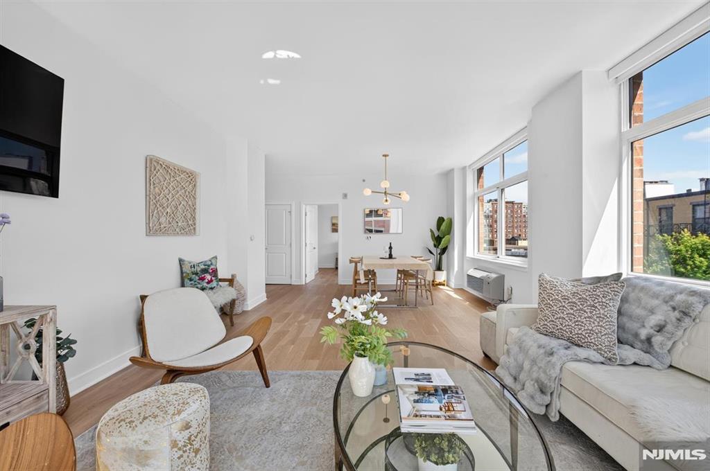 Welcome to this exceptional corner residence in the sought-after Hudson Tea community. This sun-filled 2-bedroom, 2-bathroom home offers the perfect blend of luxury, comfort, and privacy. Five oversized windows with southwest and north exposures fill the home with natural light while maintaining a quiet setting. The open kitchen features a Bosch gas range, Bosch French-door refrigerator and dishwasher (both installed in 2023), tiled backsplash, ample cabinetry, and a breakfast bar. Premium Mirage engineered hardwood floors run throughout, complemented by a full-size LG washer/dryer and Google Nest thermostat. The spacious primary suite includes a custom walk-in closet and an ensuite bath with dual vanities and a glass-enclosed shower. The second bedroom is positioned on the opposite side of the home for privacy and sits near a full bath with a soaking tub. Motorized blackout and roller shades add convenience and style. Additional highlights include abundant storage, a large foyer, and a desirable location within the buildingâ€”close to garage access yet away from elevators and refuse areas for added quiet. Premium rental parking is available. Residents enjoy a 24-hour doorman, pool, roof deck, fitness center, courtyard, lounge, playroom, and PATH shuttle. The building is also undergoing a fully paid-for renovation expected later this year. All this, steps from the waterfront, top dining, and the NY Waterway ferry.