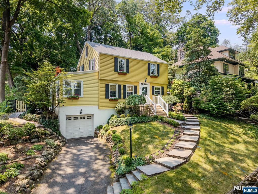 Storybook colonial set in the heart of Glen Ridge offering seasonal NYC views, timeless character, and beautifully curated updates throughout. Filled with natural light, this move-in ready home features hardwood floors, custom built-ins, designer lighting and central air. The renovated kitchen showcases quartz countertops and backsplash, inset cabinetry, farmhouse sink, and stainless steel appliances. The second floor offers three comfortable bedrooms and an updated hall bath with radiant heated floors. The finished lower level adds valuable living space with recreation room, full bath, laundry and convenient attached garage access. Outside enjoy the private brick patio and tiered backyard with level lawn space ideal for entertaining, relaxing, or play. Ideally located near Glen Ridge's top rated schools, Midtown direct train to NYC, bus service, parks and more! This home offers the perfect blend of classic architecture, thoughtful updates, and the exceptional Glen Ridge lifestyle!
