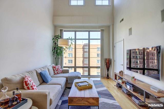 Enjoy luxury living in this beautifully renovated 2 Bedroom + Den / 2 Full Bathroom home located in the highly sought-after Hudson Club community. Spanning approximately 1,134 square feet, this residence features an open-concept layout with soaring vaulted ceilings and floor-to-ceiling windows that fill the home with natural light. The modern kitchen is equipped with stainless steel appliances, granite countertops, and ample cabinetry, seamlessly connecting to the spacious living and dining areas, perfect for both everyday living and entertaining. The primary suite offers a generous walk-in closet and an updated en-suite bathroom. Upstairs, the spacious second bedroom features excellent closet space and access to a beautifully renovated full bathroom. A custom loft area provides the perfect space for a home office, den, or additional storage. Additional highlights include an in-unit washer and dryer and one indoor parking space. The monthly maintenance fee conveniently includes gas, water, hot water, parking, amenities, and cable/internet. Residents of Hudson Club enjoy an impressive array of resort-style amenities, including a concierge, outdoor pool with jacuzzi, fitness center, basketball court, cinema room, social lounge, business center, fire pits, and more. Ideally located just around the corner from ACME, Paris Baguette, the NY Waterway Ferry, Hudson-Bergen Light Rail, and NJ Transit bus service, offering an easy commute to Manhattan.