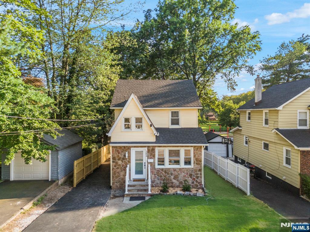 This fully renovated Colonial in the heart of Teaneck blends classic charm with modern living across a spacious, open-concept layout. With 3 bedrooms, 2.5 baths, and seamless flow between the living room, dining area, and kitchen, the home is designed for both comfort and entertaining. The first floor features a bright and airy common space anchored by original stained glass accent windows in the living area. The kitchen is thoughtfully updated with quartz countertops, custom cabinetry, and stainless steel appliances, all open to the dining and living areas for effortless gatherings. A first-floor bedroom and half bath add convenience for guests or extended family. Upstairs, the serene primary suite includes a generous walk-in closet and direct access to a fully finished attic, ideal as a private office, bonus room, or extra storage. Bathrooms throughout the home are finished in beautiful, full-height tile for a clean, spa-like feel. The finished basement with a full bath offers even more flexible space for recreation or hosting. Out back, a large deck leads to a spacious yard with a patio and private gated access to a neighboring park. Perfect for outdoor entertaining and families with kids. Additional updates include all-new HVAC, roof, electrical, and plumbing systems, plus a 3-car driveway and a fenced backyard.
