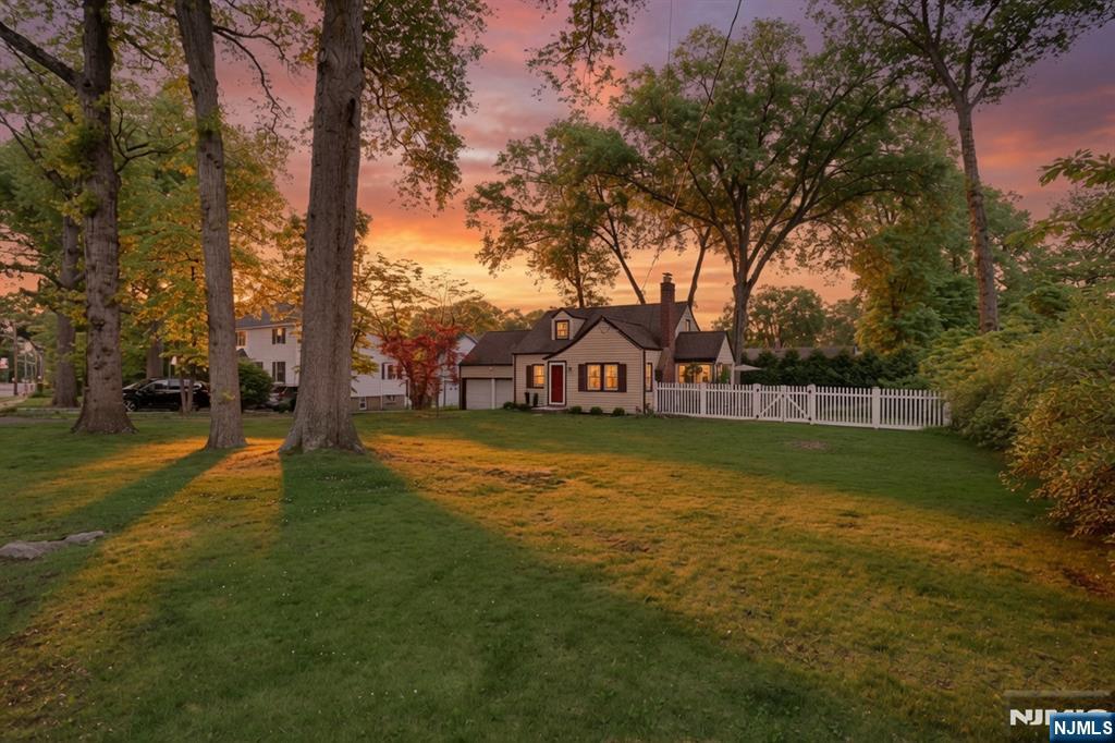 Majestically setback and nestled among mature shade trees on an expansive 100' x 137' lot. Perfect for future expansion! A gracious foyer opens into a spacious living/dining room featuring a stately fireplace and rich period moldings. Enter the inviting 3 season porch, leading to all-weather deck and serene backyard. The updated gourmet kitchen, renovated in 2016, offers a charming breakfast nook with bay window overlooking the yard, plus a spice closet and separate pantry. The first floor includes two bedrooms and a full bath. The second floor features the primary bedroom and a fourth bedroom with two attic closets and an additional hall closet. The lower level provides a HUGE family room, laundry area, storage, and utilities. A two car attached garage offers convenient basement access. Outside, enjoy a fenced backyard, firepit, and lush landscaping â€” perfect for relaxing or entertaining. NYC bus stop is just steps away, and youâ€™re moments from Westwoodâ€™s fantastic restaurants and shopping. A home youâ€™ll truly LOVE living in!