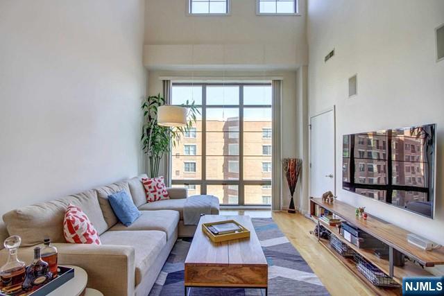 Enjoy luxury living in this beautifully renovated 2 Bedroom + Den / 2 Full Bathroom home located in the highly sought-after Hudson Club community. Spanning approximately 1,134 square feet, this residence features an open-concept layout with soaring vaulted ceilings and floor-to-ceiling windows that fill the home with natural light. The modern kitchen is equipped with stainless steel appliances, granite countertops, and ample cabinetry, seamlessly connecting to the spacious living and dining areas, perfect for both everyday living and entertaining. The primary suite offers a generous walk-in closet and an updated en-suite bathroom. Upstairs, the spacious second bedroom features excellent closet space and access to a beautifully renovated full bathroom. A custom loft area provides the perfect space for a home office, den, or additional storage. Additional highlights include an in-unit washer and dryer and one indoor parking space. The monthly maintenance fee conveniently includes gas, water, hot water, parking, amenities, and cable/internet. Residents of Hudson Club enjoy an impressive array of resort-style amenities, including a concierge, outdoor pool with jacuzzi, fitness center, basketball court, cinema room, social lounge, business center, fire pits, and more. Ideally located just around the corner from ACME, Paris Baguette, the NY Waterway Ferry, Hudson-Bergen Light Rail, and NJ Transit bus service, offering an easy commute to Manhattan.